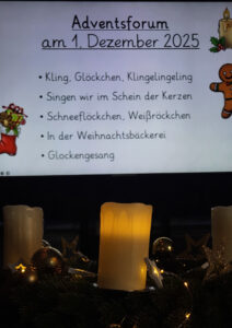 Im Vordergrund leuchtende Kerzen und weihnachtliche Dekoration, im Hintergrund eine Leinwand mit dem Programm des Adventsforums am 1. Dezember.